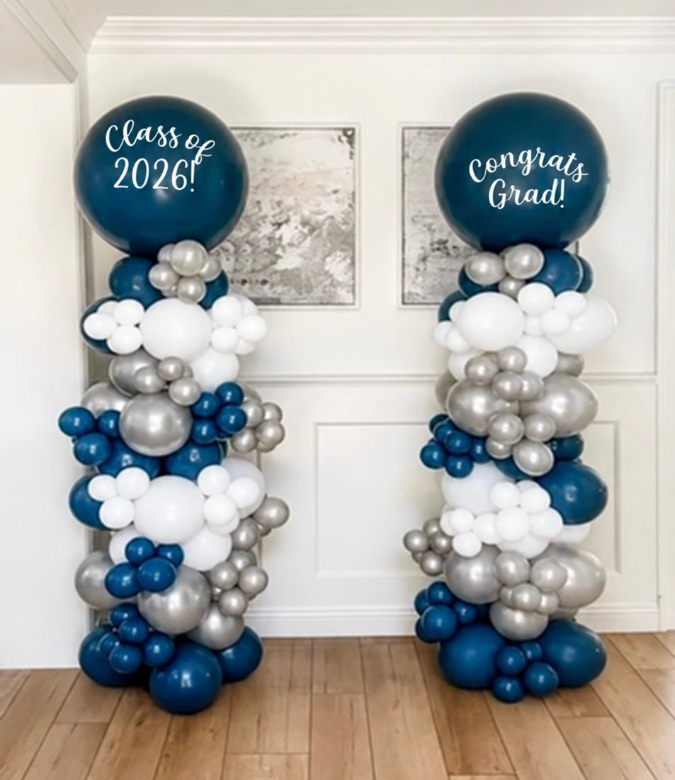 Navy, white and chrome silver balloon columns with "Class of 2026" and "Congrats Grad" toppers