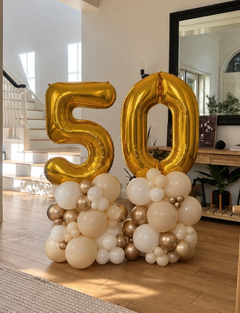 Gold 50 foil balloon number stacks with sand, ivory and chrome gold balloon clusters